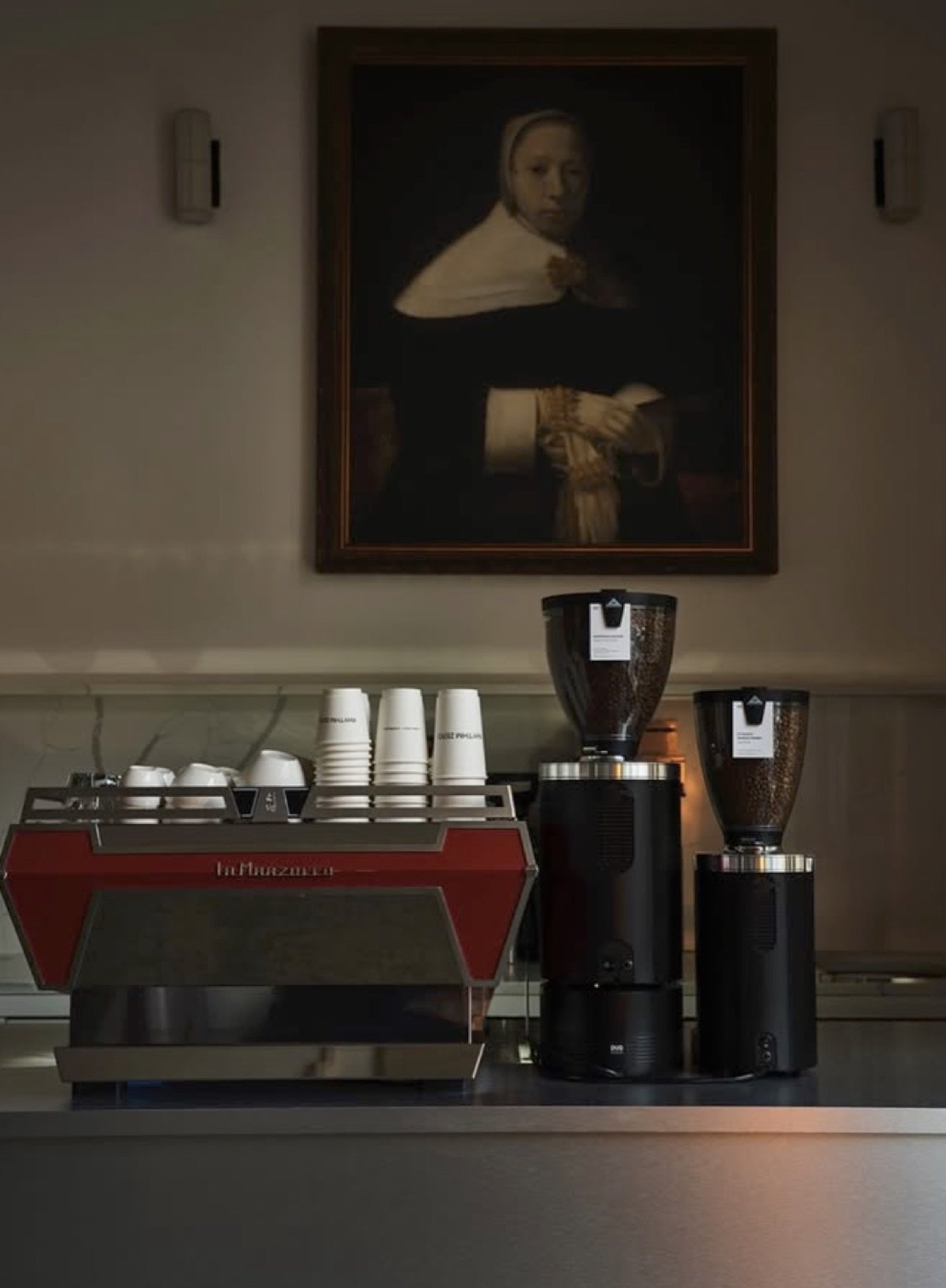 A 17th century portrait hanging above the red espresso machine at Rhythm Zero